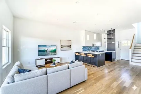 a living room with furniture and a kitchen view
