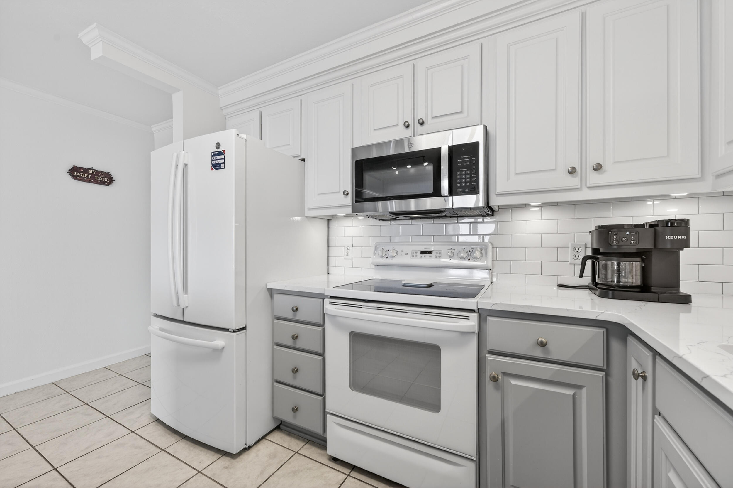 30 Moreno Point Road, Unit 502A Destin, FL 32541 - Photo 6 of 71 a kitchen with white cabinets and stainless steel appliances