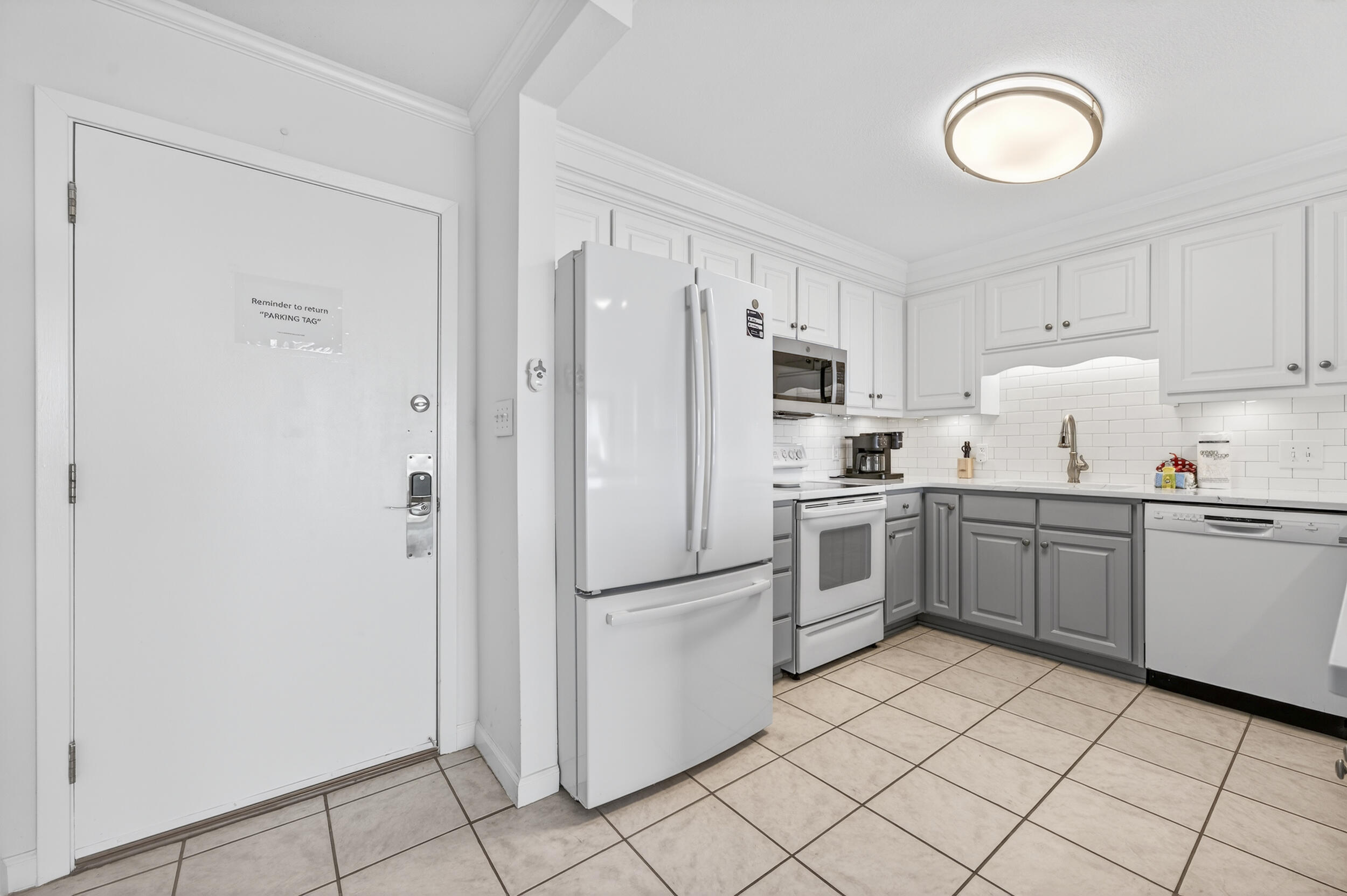 30 Moreno Point Road, Unit 502A Destin, FL 32541 - Photo 9 of 71 a kitchen with white cabinets and white appliances