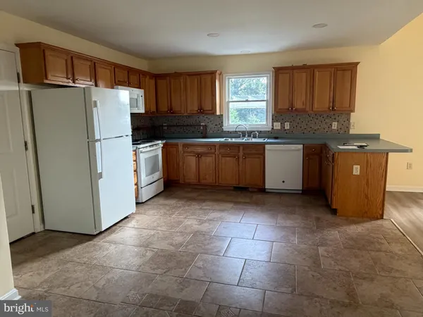 a kitchen with granite countertop a refrigerator and a stove top oven