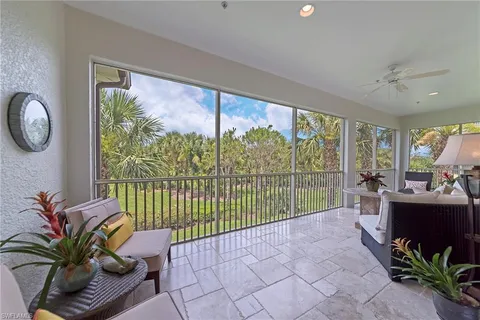 a living room with furniture a large window and a potted plant