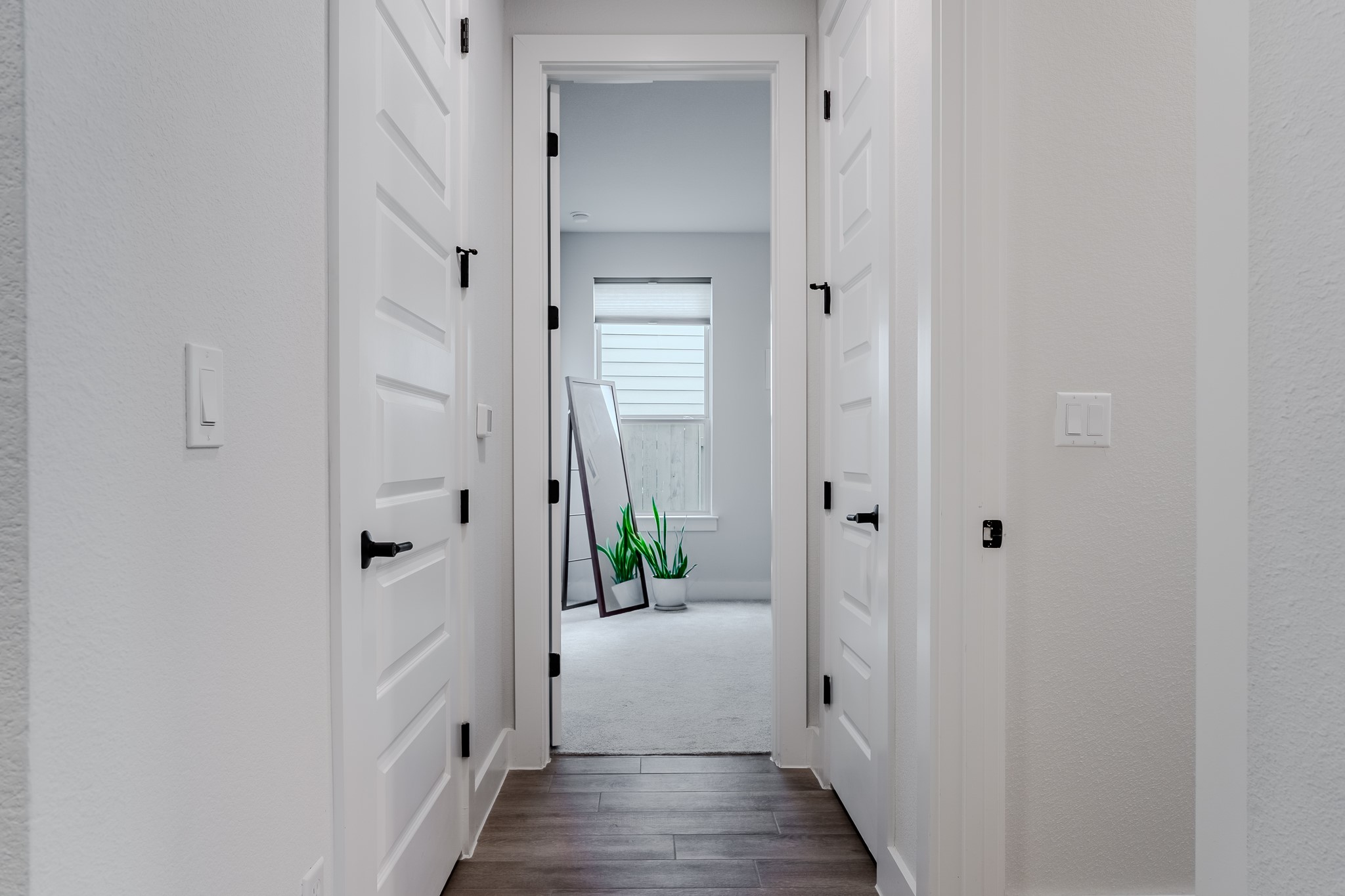 8109 Edmondson Bend Austin, TX 78744 - Photo 8 of 38 A well-lit corridor with rich wood flooring leads to a serene room.