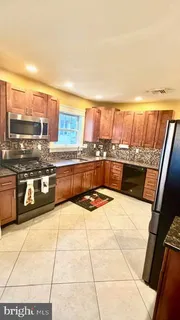 a kitchen with stainless steel appliances kitchen island granite countertop a sink and cabinets