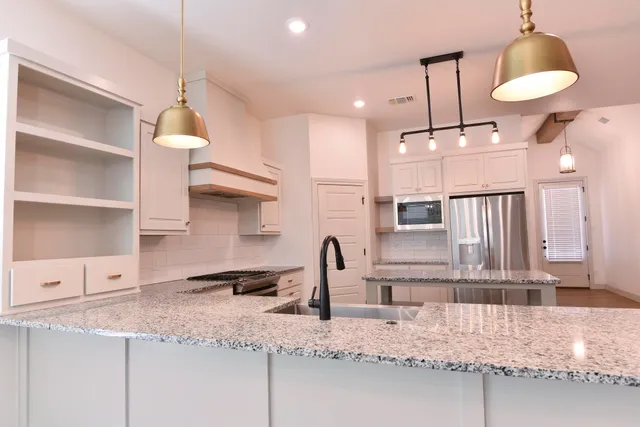 a kitchen with counter top space a sink and appliances