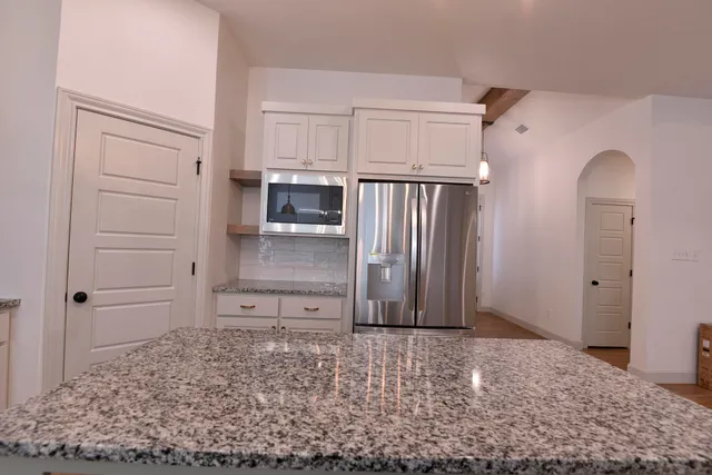 a view of a kitchen with refrigerator and wooden cabinets