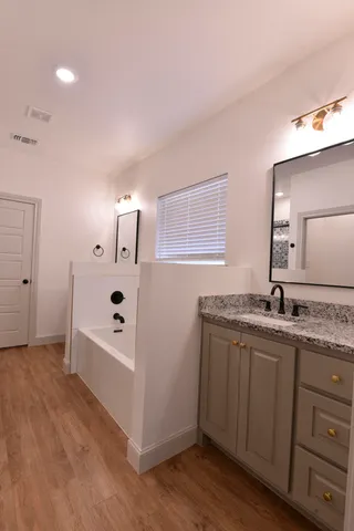 a bathroom with a granite countertop sink and a mirror