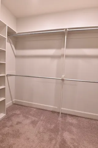 a view of walk in closet with empty racks