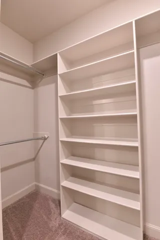 a view of walk in closet with empty racks