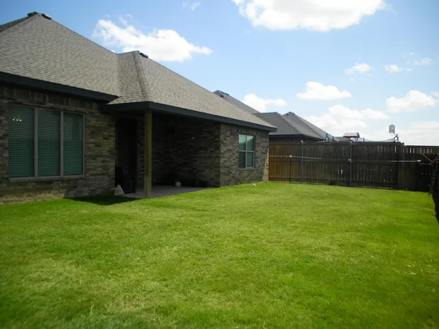a backyard of a house with lots of green space and mountain view in the back