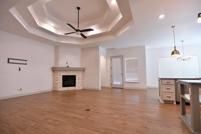 a view of empty room with wooden floor and fireplace