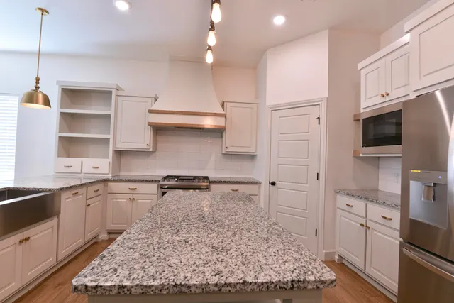 a kitchen with white cabinets and appliances
