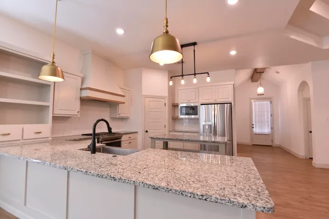 a kitchen with kitchen island a refrigerator and a sink