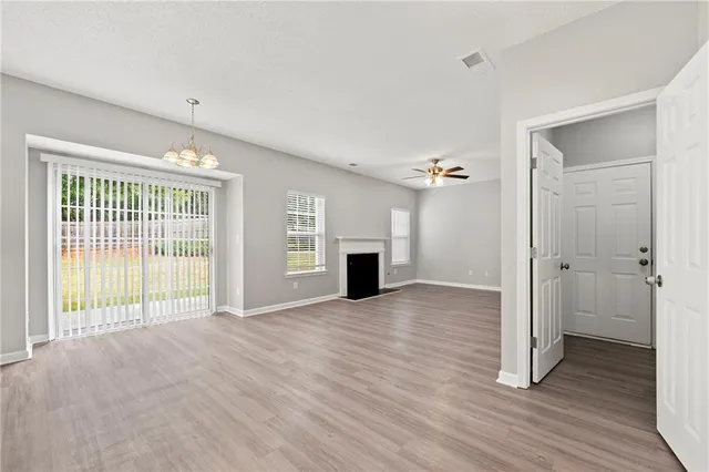 wooden floor fireplace and windows in an empty room