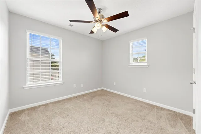 an empty room with a window and a ceiling fan