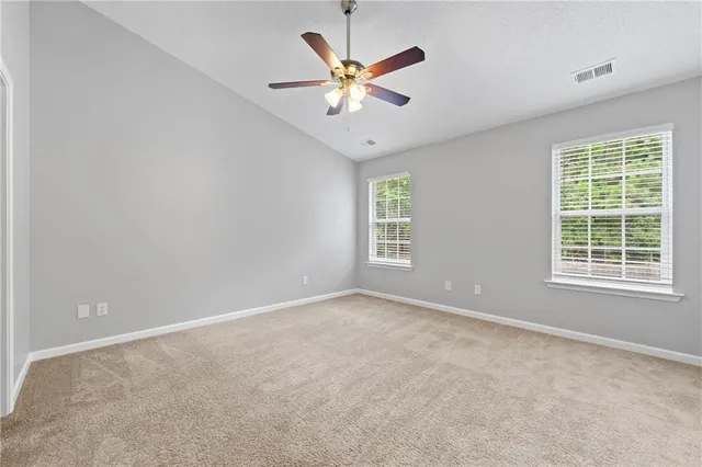 an empty room with window and a ceiling fan