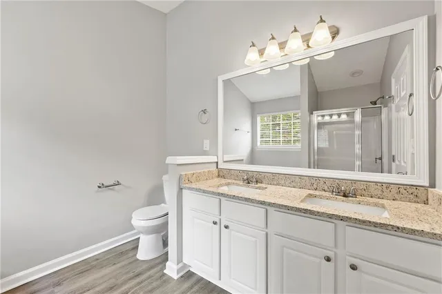 a bathroom with a granite countertop sink a toilet and a mirror