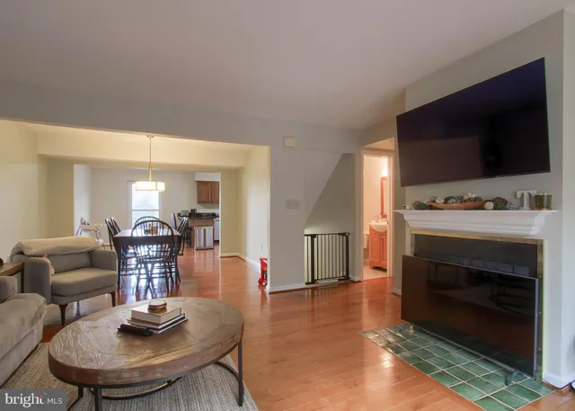 a living room with furniture a flat screen tv and a refrigerator