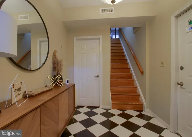 a kitchen with stainless steel appliances granite countertop a stove top oven a sink dishwasher a refrigerator and a dining table with wooden cabinet