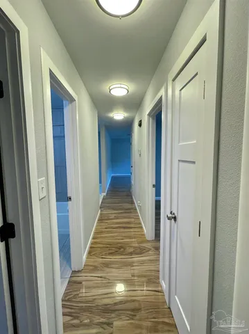 a view of a hallway with wooden floor and staircase