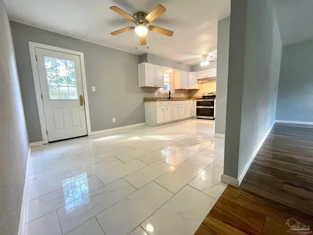 a view of a kitchen with wooden cabinet and a ceiling fan