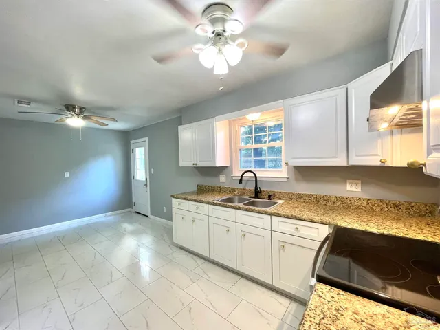 a kitchen with a sink cabinets and window