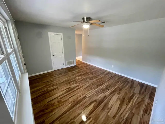 a view of empty room with wooden floor