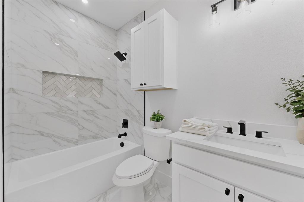 10110 Budtime Lane Dallas, TX 75217 - Photo 18 of 34 a bathroom with a sink a toilet and bathtub