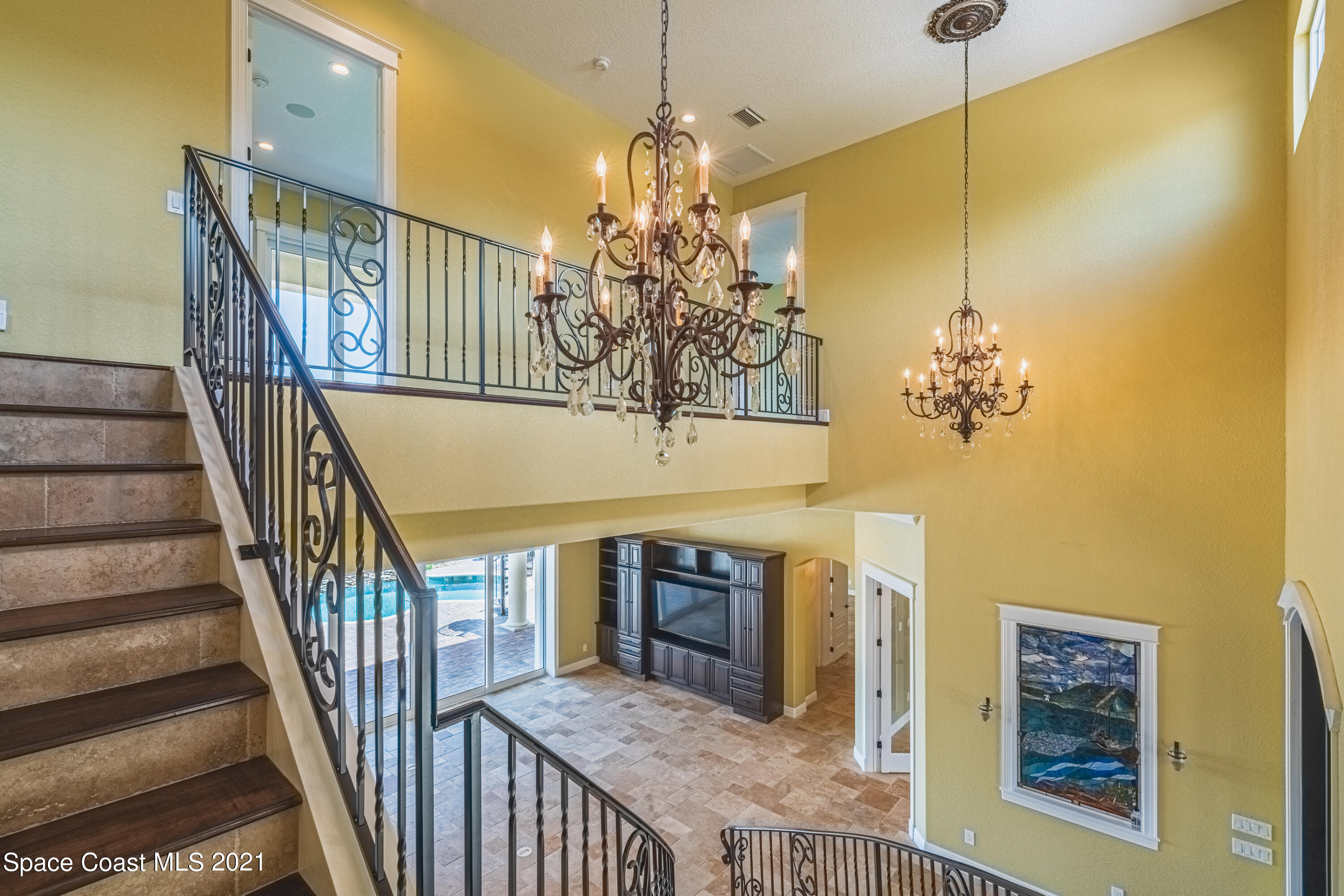 5419 Robles Lane Rockledge, FL 32955 - Photo 22 of 61 a view of a hallway to a dining room with wooden floor and chandelier