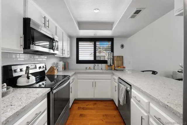 a kitchen with a sink stove top oven and cabinets