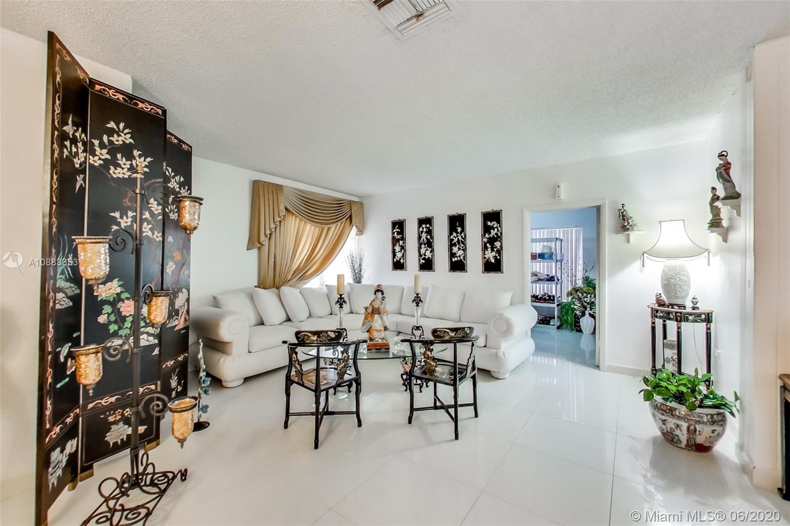 63 Southwest 31st Road Miami, FL 33129 - Photo 11 of 34 a living room with furniture a lamp and a potted plant