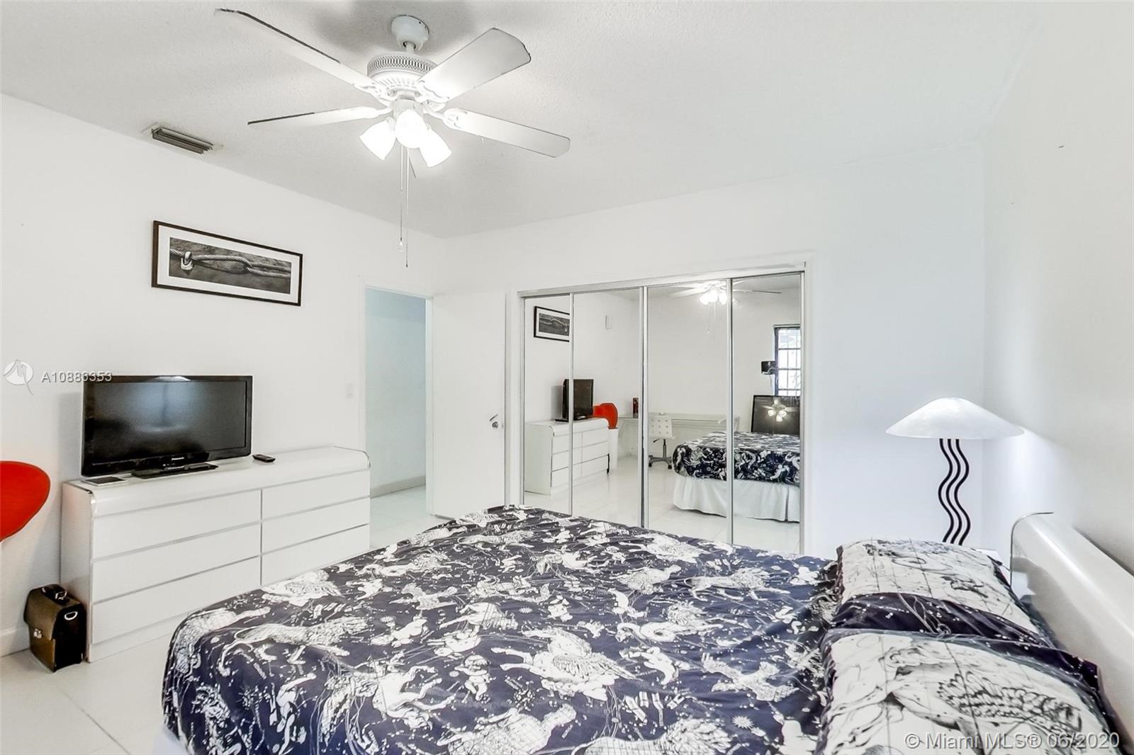63 Southwest 31st Road Miami, FL 33129 - Photo 22 of 34 a bedroom with a bed and a flat tv screen on dresser