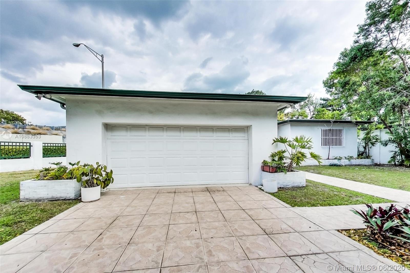 63 Southwest 31st Road Miami, FL 33129 - Photo 4 of 34 a front view of a house with a yard and a garage