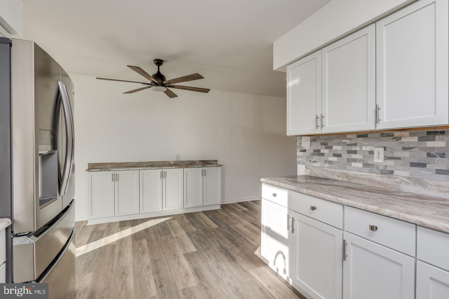238 West Center Street Clayton, NJ 08312 - Photo 8 of 30 a kitchen with cabinets wooden floor and a refrigerator