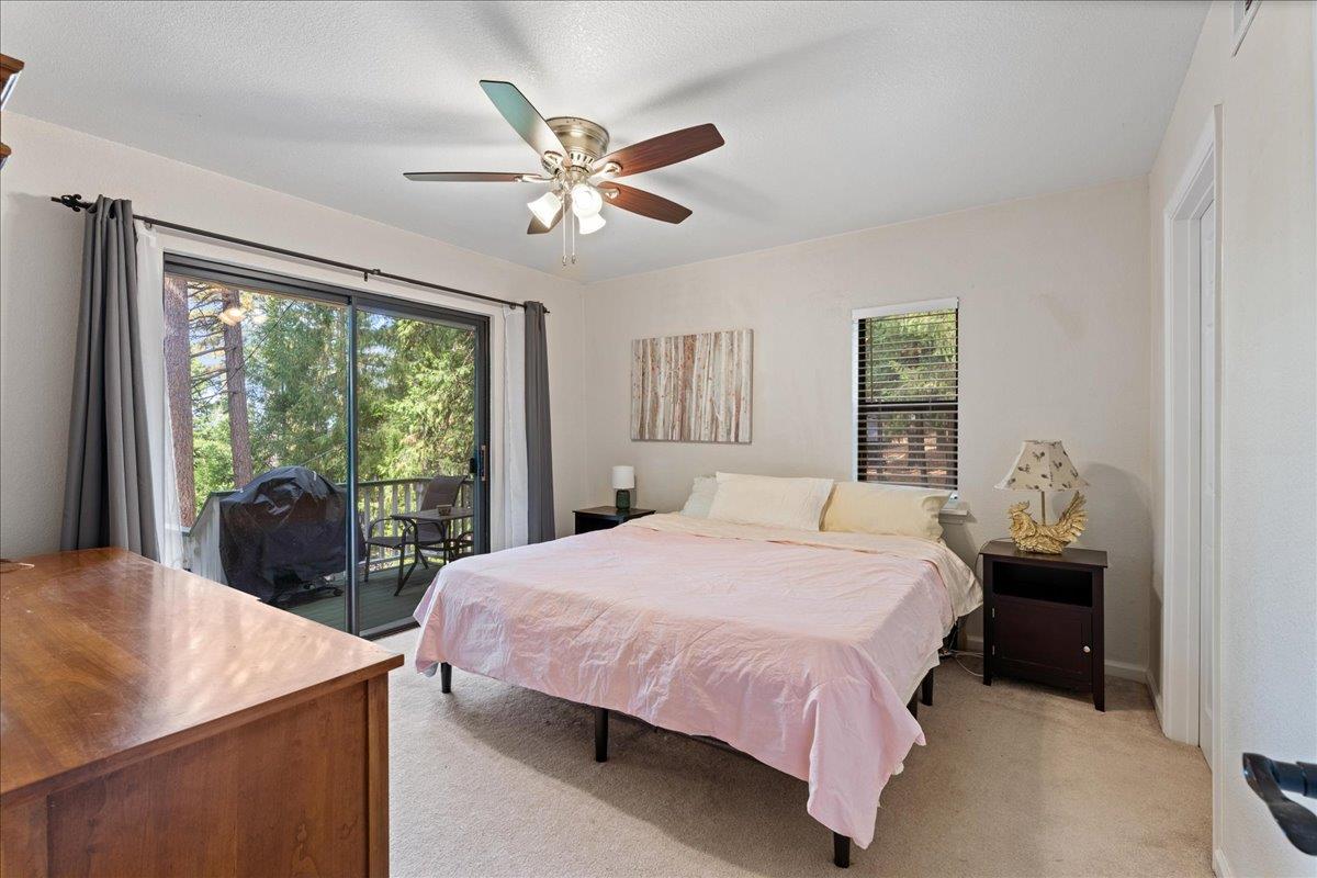 5360 Pine Ridge Drive Grizzly Flats, CA 95636 - Photo 19 of 36 a bedroom with a large bed and a chandelier