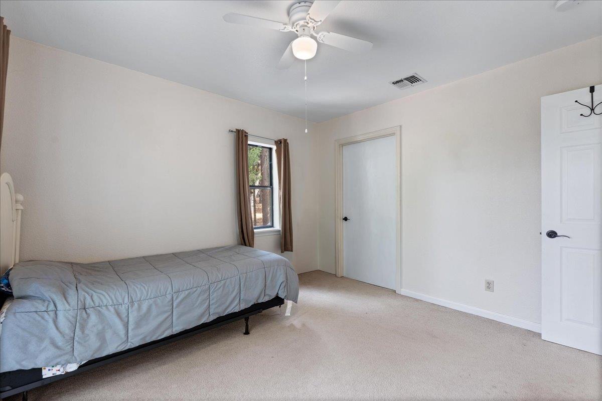 5360 Pine Ridge Drive Grizzly Flats, CA 95636 - Photo 26 of 36 a bedroom with a bed and a chandelier