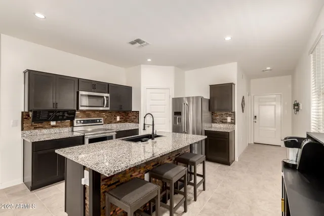 a kitchen with refrigerator a stove and a sink