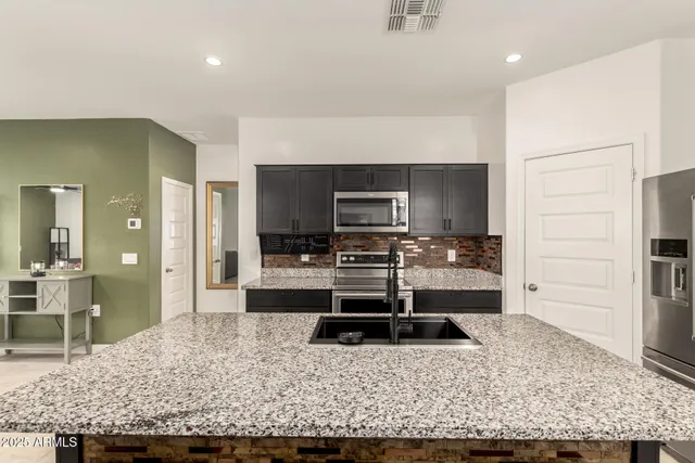 a kitchen with a stove and a wooden floor