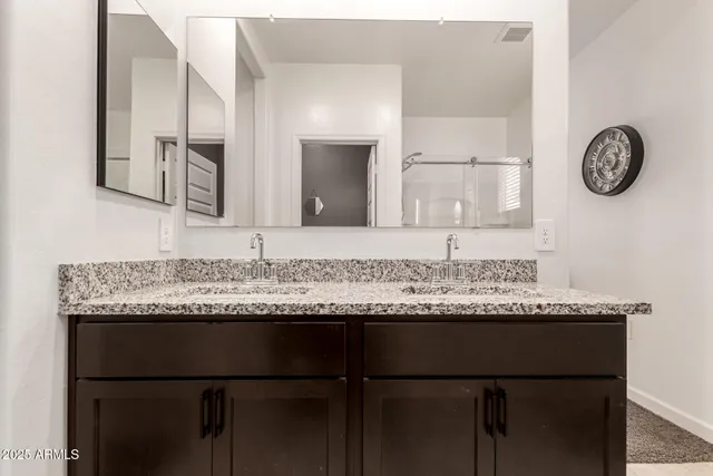 a bathroom with a granite countertop sink and a mirror