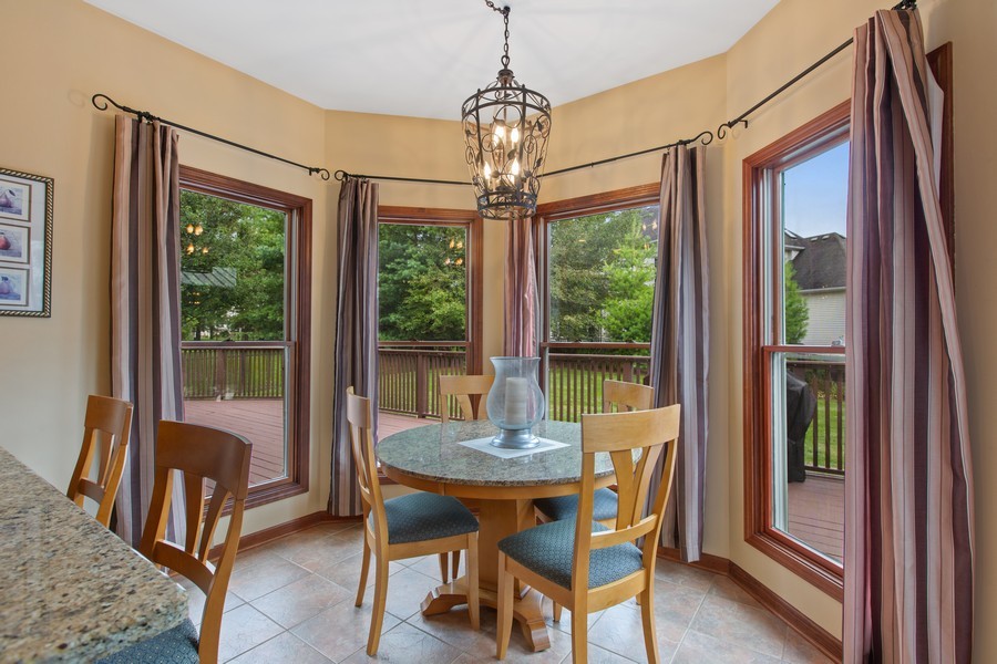 1 Walnut Lane Sugar Grove, IL 60554 - Photo 8 of 35 a dining room with wooden floor a chandelier a glass table and chairs