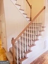 a view of staircase with wooden floor and white walls