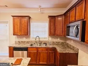 a kitchen with granite countertop a sink stove and cabinets