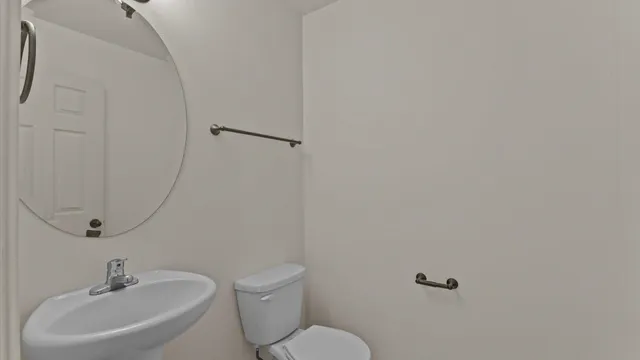 a bathroom with a sink mirror and toilet