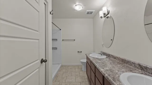 a bathroom with a granite countertop sink a mirror and a shower
