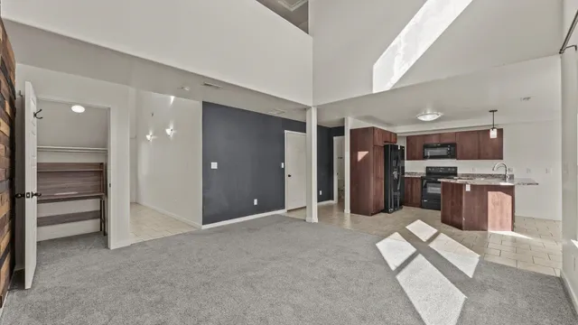 a open kitchen with stainless steel appliances kitchen island granite countertop a refrigerator and cabinets