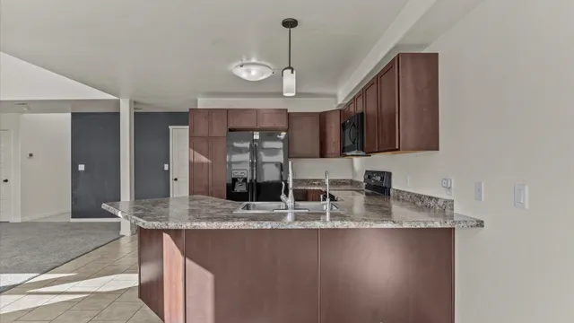 a kitchen with kitchen island granite countertop a sink cabinets and stainless steel appliances