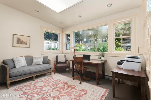 a living room with furniture a rug and a large window