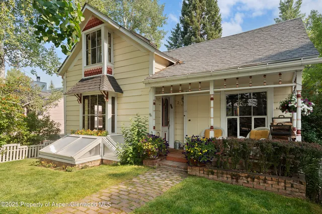 a view of a house with a yard and lawn chairs with plants