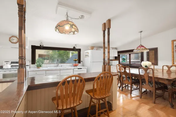 a dining room with furniture a chandelier and wooden floor