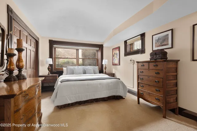 a bedroom with a bed a couch and large window