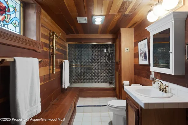 a bathroom with a sink a toilet a mirror and shower